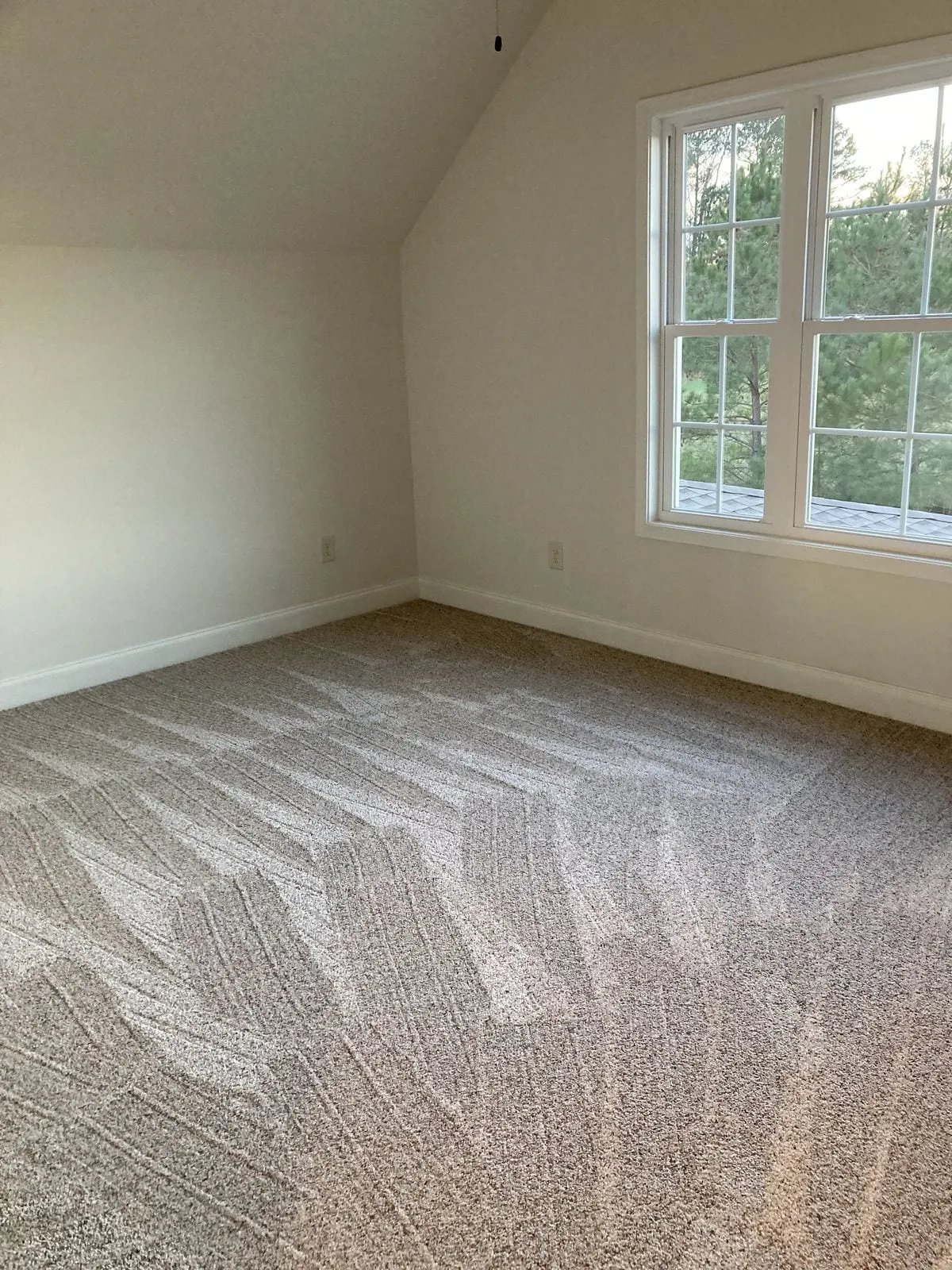 Freshly vacuumed bedroom carpet with crisp cleaning lines